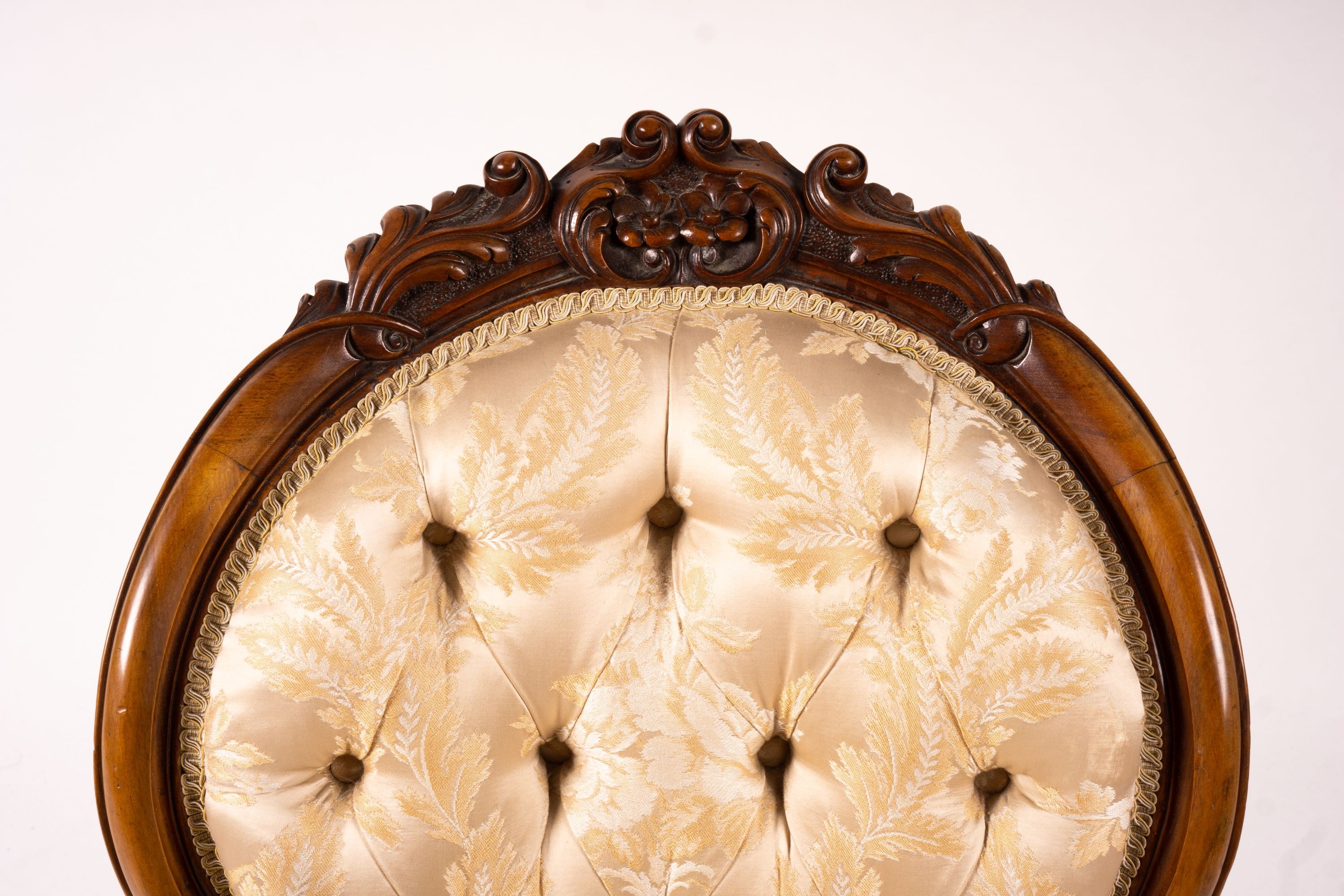 A late Victorian carved walnut three piece salon suite, comprising chaise longue, open armchair and nursing chair